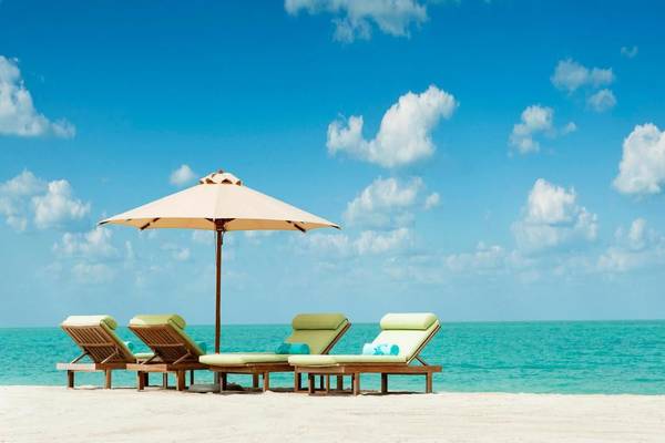 Strand mit Liegen und Sonnenschirm am The St. Regis Saadiyat Island Resort