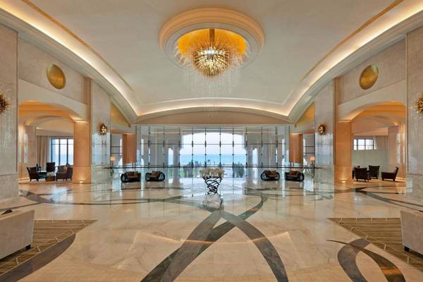 Lobby des St. Regis Saadiyat Island Resort mit großem Kronleuchter und Blick aufs Meer.