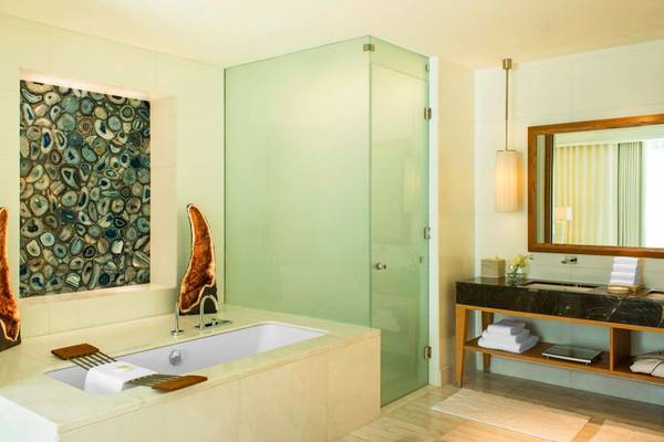 Das Badezimmer im St. Regis Saadiyat Island Resort mit Badewanne, Glasdusche und Marmorwaschtisch.