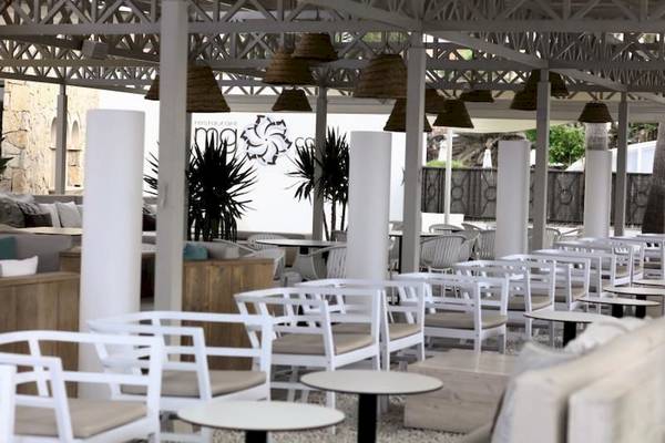 Restaurant-Terrasse des Playa Golf Hotels mit weißen Stühlen und Tischen.