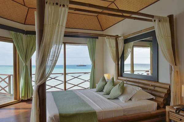 Innenansicht eines Schlafzimmers im Safari Island Resort mit Blick auf das Meer.