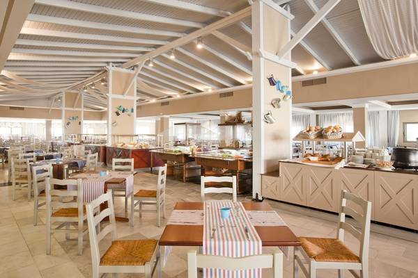 Innenansicht des Restaurants im Kipriotis Village Resort mit gedeckten Tischen und Buffet.