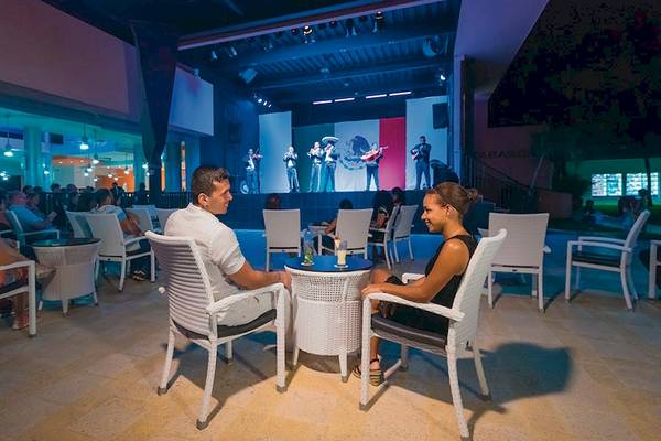 Paar beim Abendessen im Riu Lupita Hotel mit Live-Musik im Hintergrund.