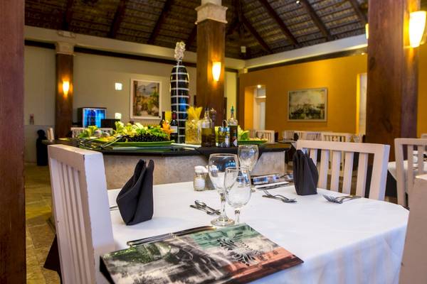 Speisesaal im Vista Sol Punta Cana Beach Resort & Spa mit gedeckten Tischen und dekorierten Speisenplatten.