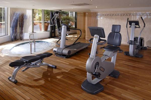 Fitnessbereich im Aquila Porto Rethymno Hotel mit Whirlpool, Laufband und anderen Geräten.