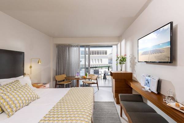 Innenansicht eines modernen Hotelzimmers von Aquila Porto Rethymno mit Blick auf die Terrasse und das Meer.