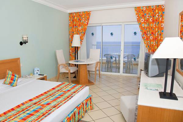 Ein Zimmer im Siva Sharm Resort & Spa mit Meerblick, einem Bett, einem Tisch und Stühlen.