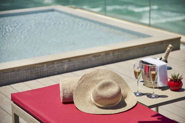 Lounge-Bereich am Pool im Pure Salt Garonda Hotel mit Champagner und Sonnenhut.