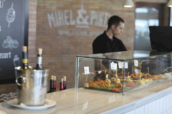 Im Pure Salt Garonda Hotel steht ein Barkeeper hinter der Theke mit verschiedenen Getränken und Speisen.