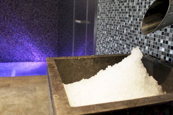 Salzbad im Pure Salt Garonda Hotel mit violetter Beleuchtung und gefliester Wand.