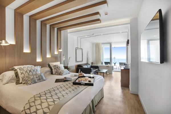 Innenansicht eines Zimmers im Pure Salt Garonda Hotel mit Bett, Möbeln und Balkon.