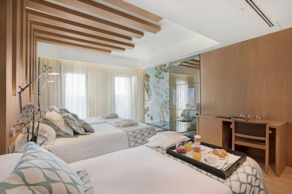 Doppelzimmer im Pure Salt Garonda Hotel mit zwei Betten, Frühstückstablett und Schreibtisch