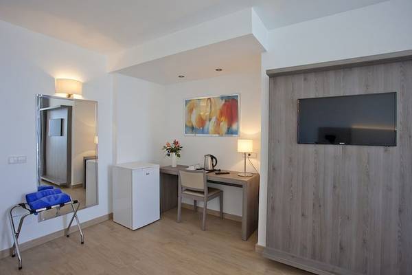 Hotelzimmer mit Schreibtisch, Stuhl, Kühlschrank, Fernseher und Spiegel im Playa Dorada Aparthotel.