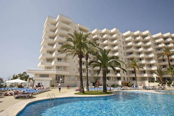 Außenbereich des Playa Dorada Aparthotels mit Pool, Palmen und Sonnenliegen.