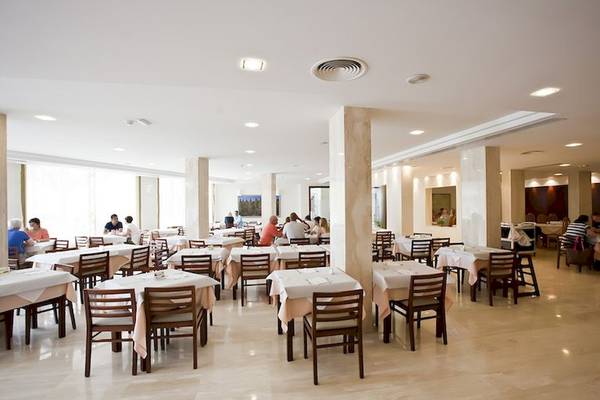 Innenansicht des Restaurants im Playa Dorada Aparthotel mit Gästen an Tischen und Stühlen.