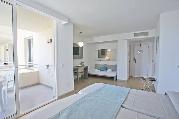 Hotelzimmer im Playa Dorada Aparthotel mit Balkon, zwei Betten und Schreibtisch.