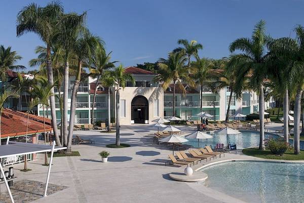 Außenbereich des Gran Ventana Beach Resort mit Swimmingpool, Liegestühlen und Palmen