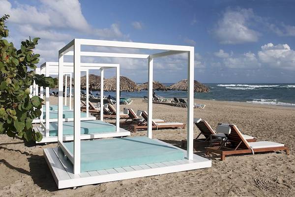 Reihe von weißen Himmelbetten auf einem Strand des Gran Ventana Beach Resorts.