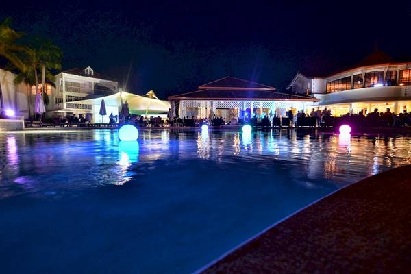 Der Pool des Gran Ventana Beach Resort bei Nacht mit farbigen Lichtern.