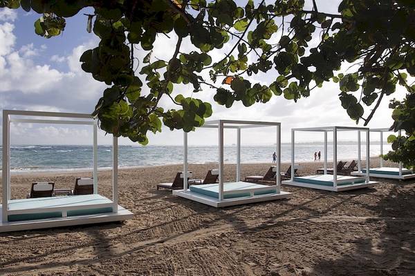 Ein Bild des Gran Ventana Beach Resort mit mehreren weißen Betten am Strand.
