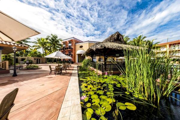 Außenbereich des Gran Ventana Beach Resort mit Teich, Tischen und Stühlen.