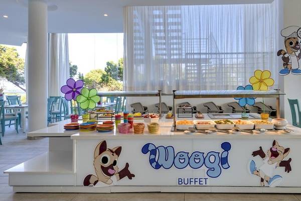 Buffetbereich im Tropic Garden Hotel Apartments mit bunten Dekorationen und Essensangeboten.