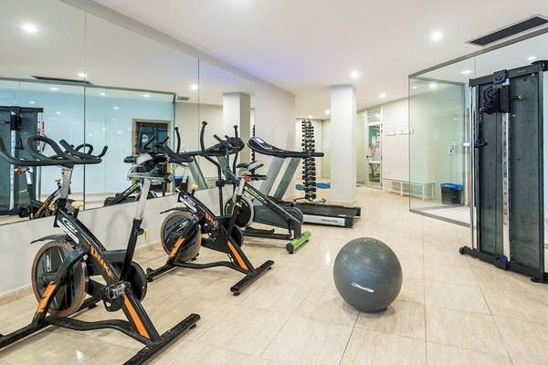 Fitnesscenter im Tropic Garden Hotel Apartments mit verschiedenen Trainingsgeräten und einer großen Kugel.