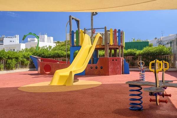 Kinderspielplatz im Tropic Garden Hotel Apartments mit gelber Rutsche und anderen Spielgeräten.