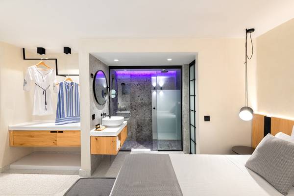 Schlafzimmer und Badezimmer im Ikaros Beach Luxury Resort & Spa mit moderner Einrichtung und hellem Design.