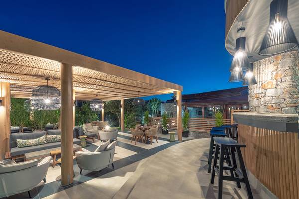 Terrasse des Ikaros Beach Luxury Resort & Spa mit Möbeln und Pflanzen bei Nacht