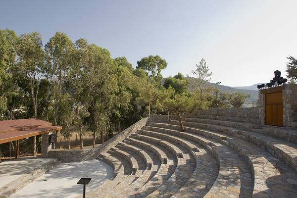 Steintheater im Freien des Ikaros Beach Luxury Resort & Spa mit Blick auf die umliegende Natur.
