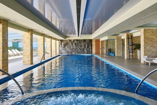 Innenpool im Ikaros Beach Luxury Resort & Spa mit Wasser und steinernen Säulen
