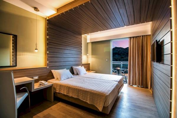 Doppelzimmer im Pegasos Deluxe Beach Hotel mit zwei Betten, Schreibtisch und Balkon.