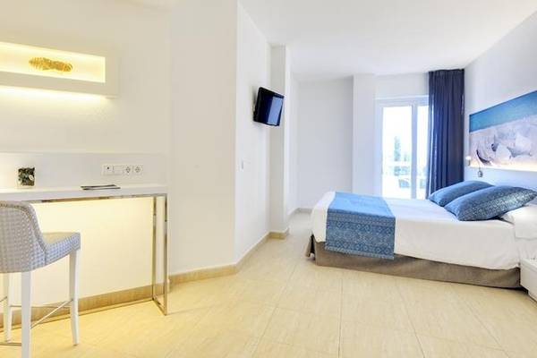 Modernes Zimmer im Tropic Garden Hotel Apartments mit Bett, Schreibtisch und Fernseher.