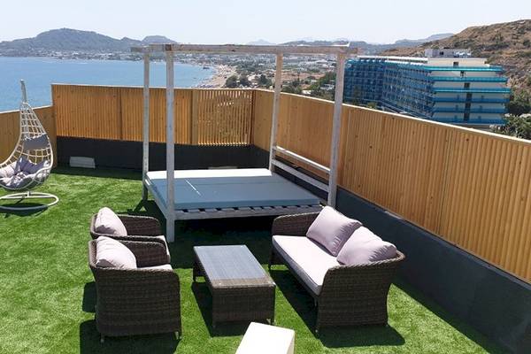 Dachterrasse des Pegasos Deluxe Beach Hotels mit Blick auf das Meer und moderne Gebäude.