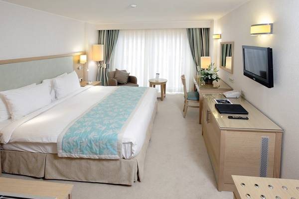 Hotelzimmer im Radisson Blu Resort & Spa in Cesme mit Bett, Schreibtisch und Fernseher.