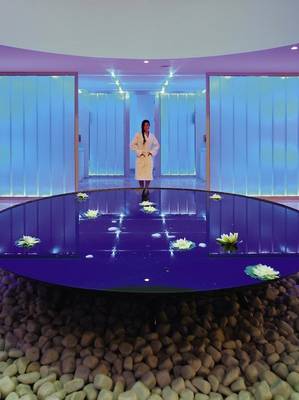 Eine Frau im Bademantel steht in einer runden Pool-Lounge im Radisson Blu Resort & Spa, Cesme.