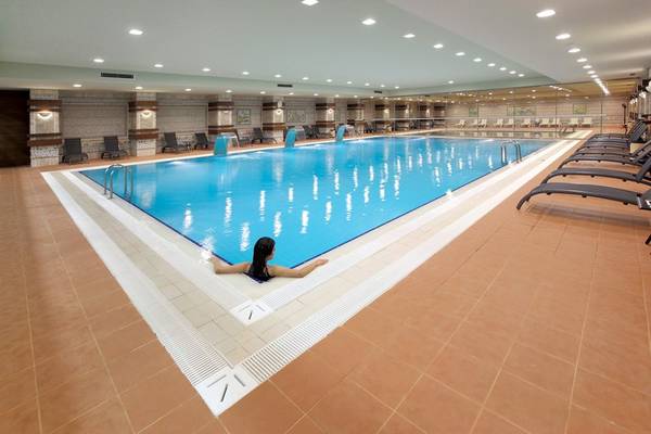 Frau schwimmt im Innenpool des Radisson Blu Resorts & Spa in Cesme