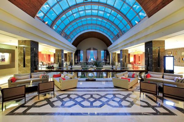 Lobby des Radisson Blu Resort & Spa in Cesme mit großen Glaskuppeln und modernen Möbeln.