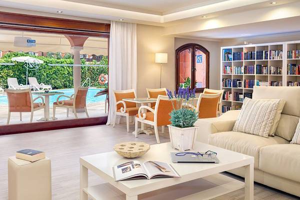 Wohnzimmer mit Zugang zur Terrasse und Swimmingpool im Ambassador Apartments