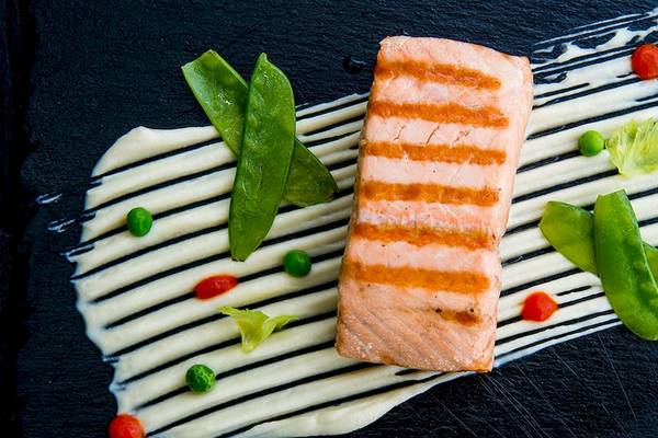 Gegrillter Lachs auf schwarzem Teller mit Gemüse