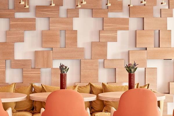 Lobby des Myconian Naia Hotels mit Sofas und Tischen vor einer Holzwand
