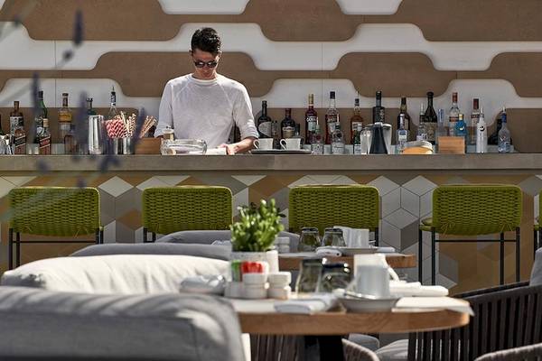 Mitarbeiter arbeitet hinter der Bar im Myconian Naia Hotel