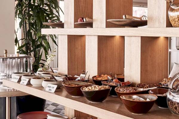 Frühstücksbuffet im Myconian Naia Hotel mit verschiedenen Schüsseln und Gläsern.