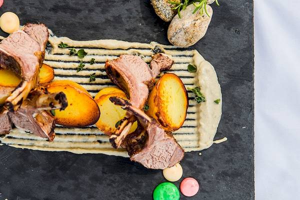 Lammkoteletts und Kartoffeln auf einer schwarzen Platte im Myconian Naia Hotel