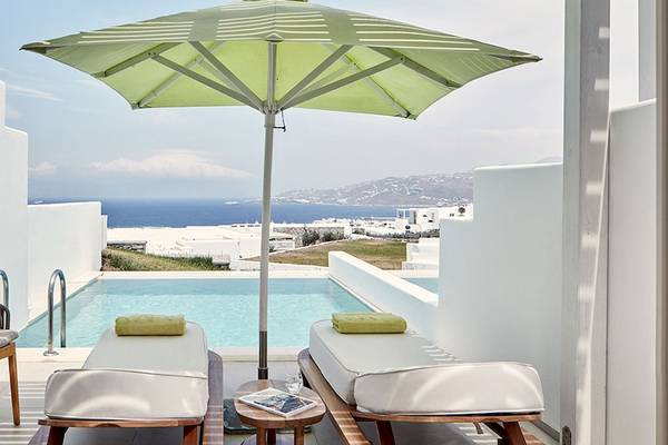 Hotelterrasse mit Pool und Sonnenschirm am Meer