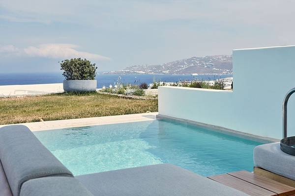 Poolbereich des Myconian Naia Hotels mit Blick auf das Meer und eine Terrasse.