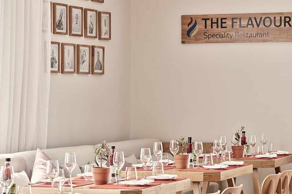 Innenbereich des The Flavour Spezialitäten Restaurant mit eingerichteten Tischen und Stühlen.