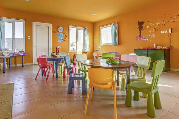 Kinderspielzimmer im Atlantica Marmari Palace mit bunten Tischen und Stühlen.