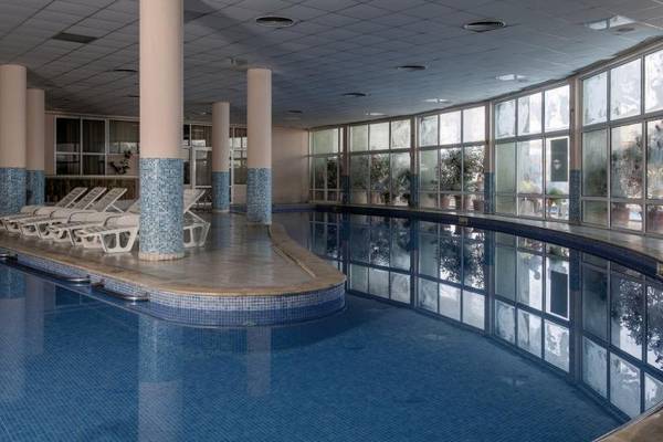 Innenpool des Sentido Golden Star Hotels mit blauem Wasser und weißen Sonnenliegen.
